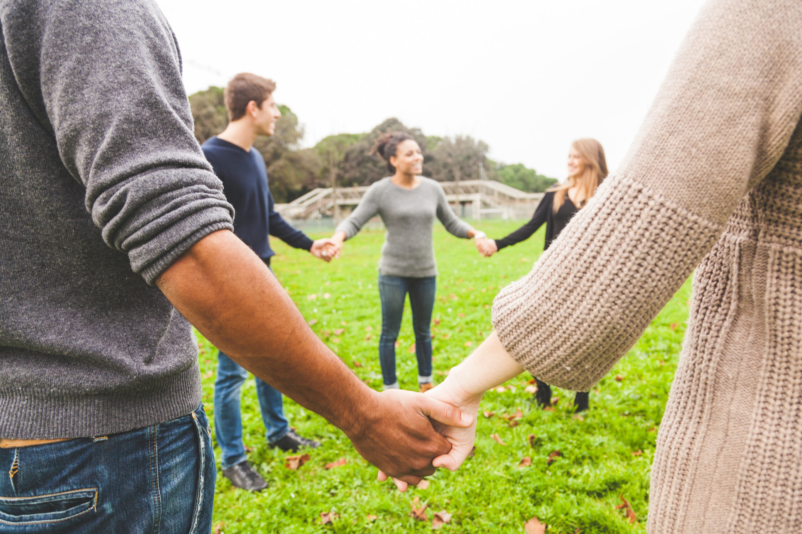 Multiethnic Group of Friends Holding Hands in a Circle